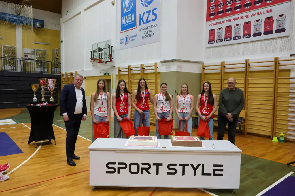 Mlade košarkarice z medaljami in darili ob predstavnikih kluba in pokrovitelja.